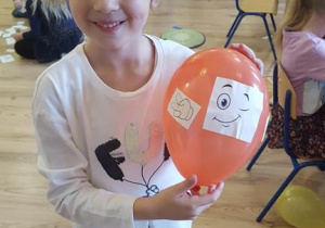 Dziewczynka prezentuje balon z wyobraźnią.